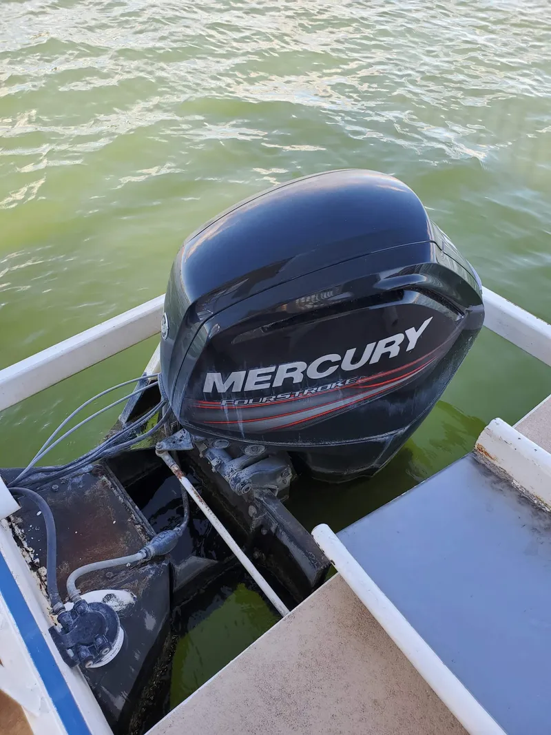 Slide: The Image of Mercury outboard motor on 1986 Hanson houseboat, floating on green water. - 8