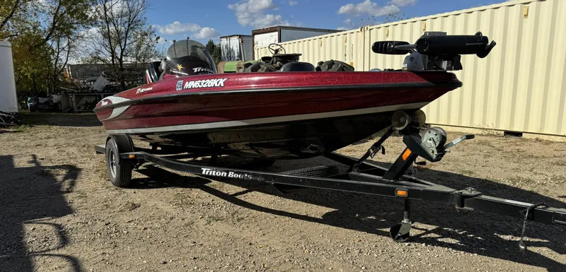 Slide: The Image of 2008 Triton 17 Explorer boat on trailer, parked outdoors under clear sky. - 2
