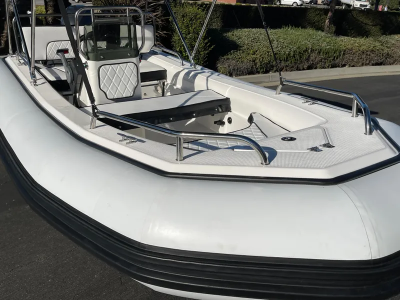 Slide: The Image of 1998 Rendova 14 inflatable boat with white deck and seating, parked outdoors. - 12