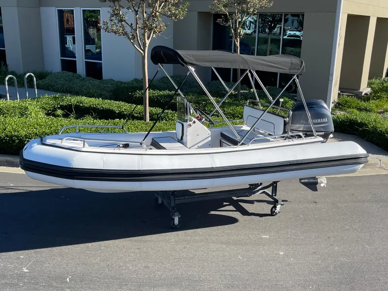 Slide: The Image of 1998 Rendova 14 inflatable boat with canopy, parked outdoors. - 14