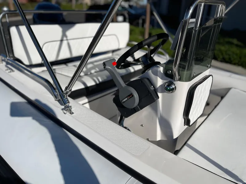 Slide: The Image of 1998 Rendova 14 boat interior with steering wheel and seating. - 18