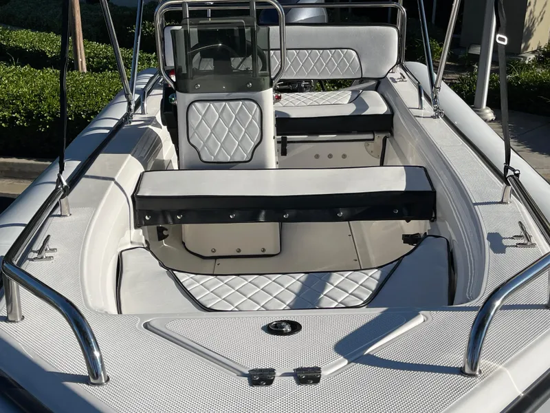 Slide: The Image of 1998 Rendova 14 boat interior with white quilted seats and chrome railings. - 2