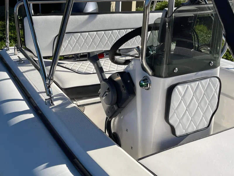 Slide: The Image of 1998 Rendova 14 boat interior with steering wheel and quilted seats. - 5