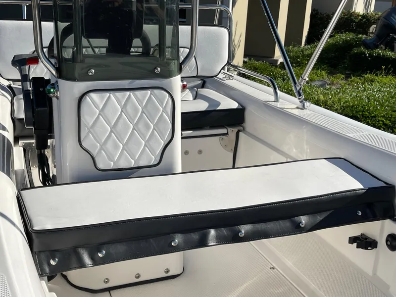 Slide: The Image of 1998 Rendova 14 boat interior with white cushioned seating and steering console. - 6