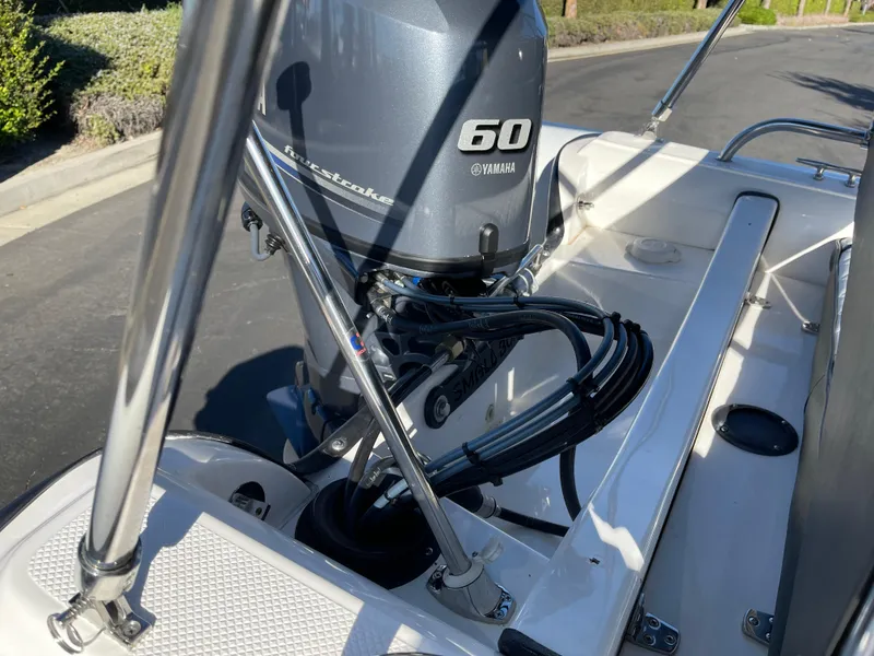 Slide: The Image of 1998 Rendova 14 boat with Yamaha 60 outboard motor, parked on a sunny street. - 9