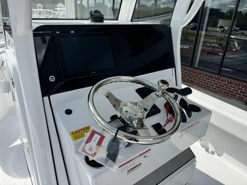 Slide: The Image of 2025 Sportsman Masters 247 Bay Boat dashboard with steering wheel and controls. - 10