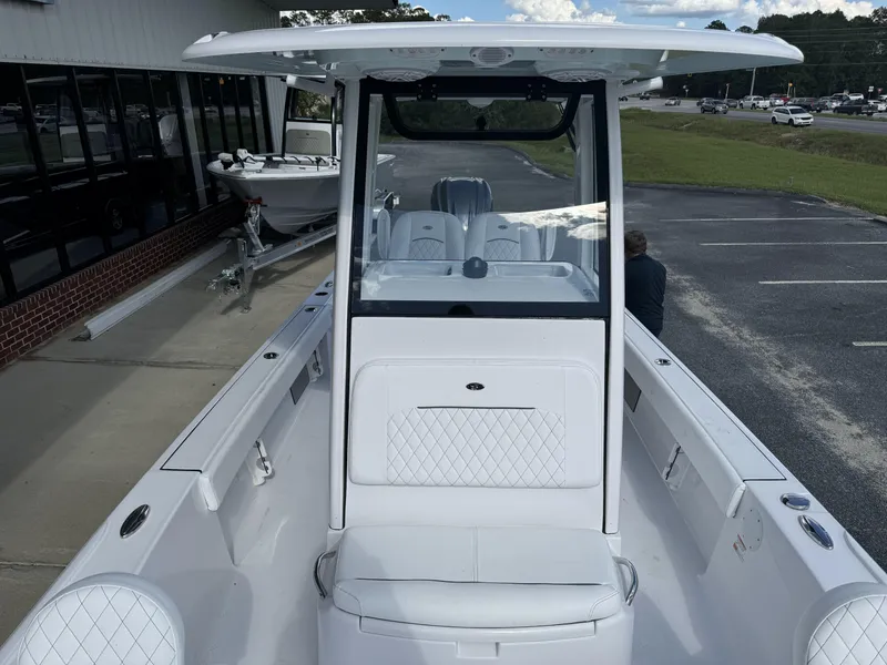 Slide: The Image of 2025 Sportsman Masters 247 Bay Boat, white interior, parked outdoors near a building. - 13