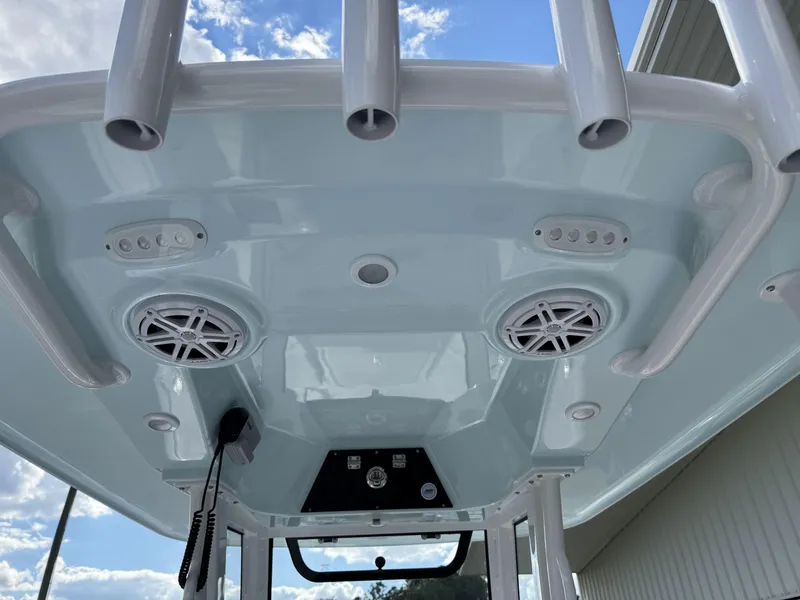 Slide: The Image of 2025 Sportsman Masters 247 Bay Boat T-top with speakers and rod holders. - 14