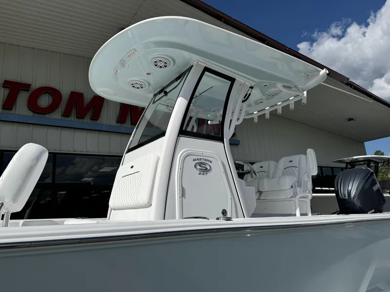 Slide: The Image of 2025 Sportsman Masters 247 Bay Boat with T-top and seating, displayed outdoors. - 8