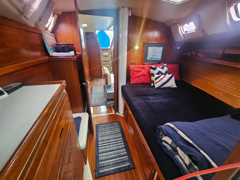 Slide: The Image of Cozy interior of a 1990 Catalina 42 sailboat with wooden finishes and comfortable bedding. - 15