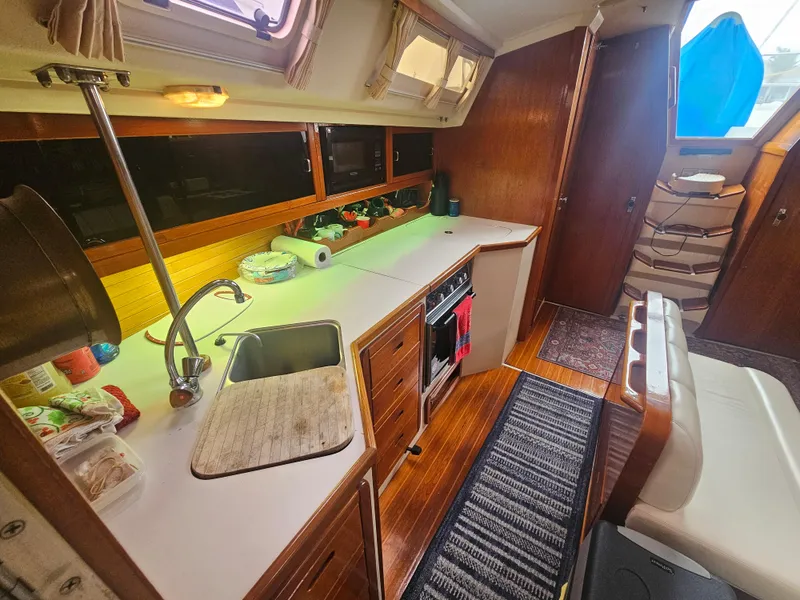 Slide: The Image of Interior of 1990 Catalina 42 sailboat with kitchen, sink, and wooden cabinetry. - 18