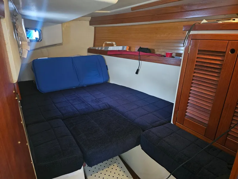 Slide: The Image of Cozy cabin interior of a 1990 Catalina 42 sailboat with blue bedding and wooden accents. - 19