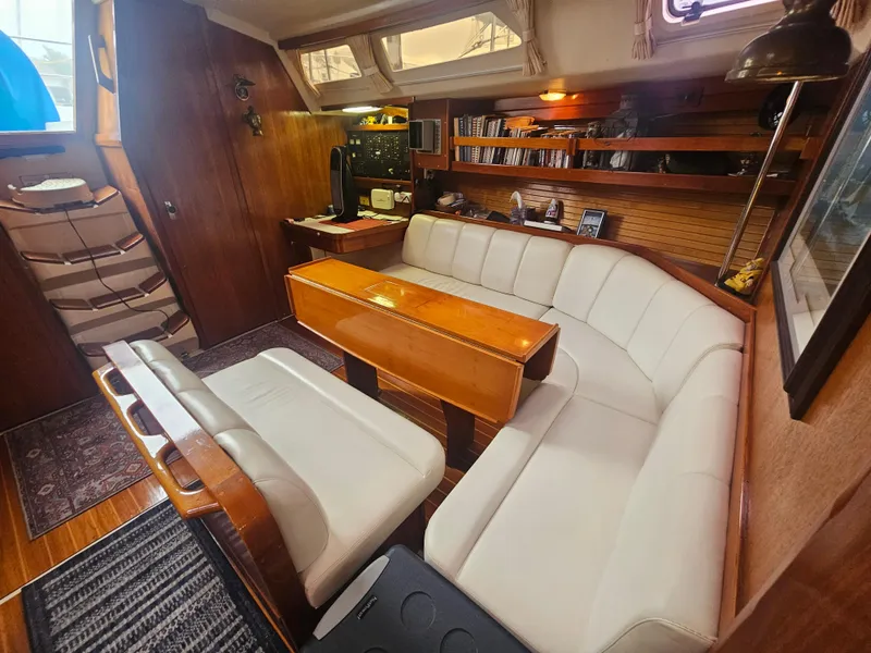 Slide: The Image of Interior of a 1990 Catalina 42 sailboat with white seating and wooden accents. - 21