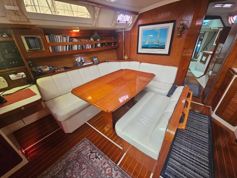 Slide: The Image of Cozy interior of 1990 Catalina 42 sailboat with wooden table and cushioned seating. - 22