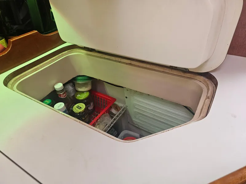 Slide: The Image of Open storage compartment on 1990 Catalina 42 yacht, containing jars and containers. - 25