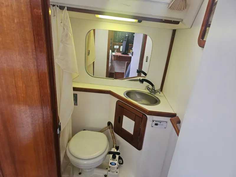 Slide: The Image of 1990 Catalina 42 yacht bathroom with sink, toilet, and mirror. - 30