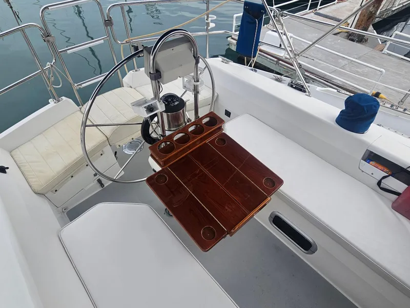 Slide: The Image of Cockpit of a 1990 Catalina 42 sailboat with wooden table and steering wheel. - 34