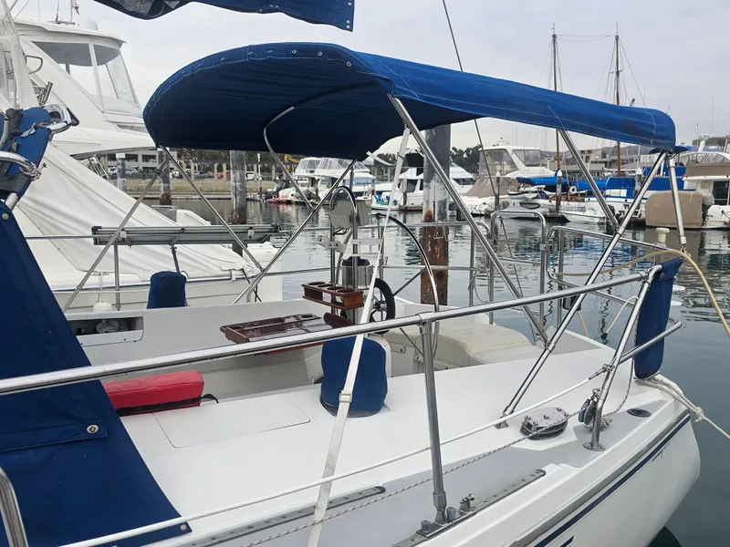 Slide: The Image of Catalina 42 sailboat from 1990 docked at marina with blue canopy and seating. - 36