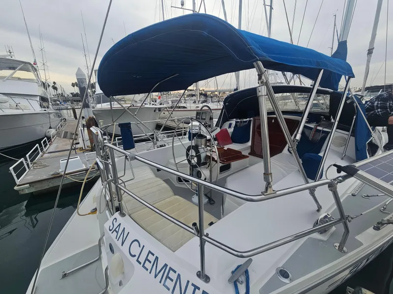 Slide: The Image of Catalina 42 sailboat, 1990 model, docked with blue canopy and visible steering wheel. - 37