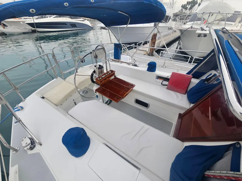 Slide: The Image of Cockpit of a 1990 Catalina 42 sailboat with blue canopy and wooden accents. - 39