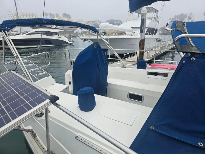 Slide: The Image of Catalina 42 sailboat from 1990 docked in a marina, featuring blue covers and solar panels. - 5