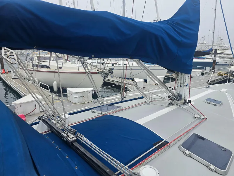 Slide: The Image of Catalina 42 sailboat, 1990 model, docked with blue sail cover and visible rigging. - 8