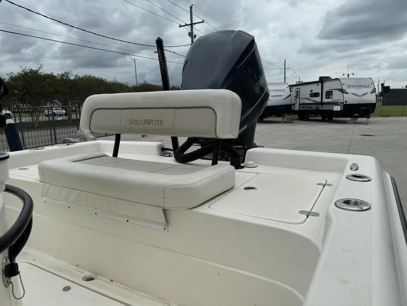 Slide: The Image of 2013 ShearWater LTZ Series 25 boat with outboard motor and seating, parked near RVs. - 15