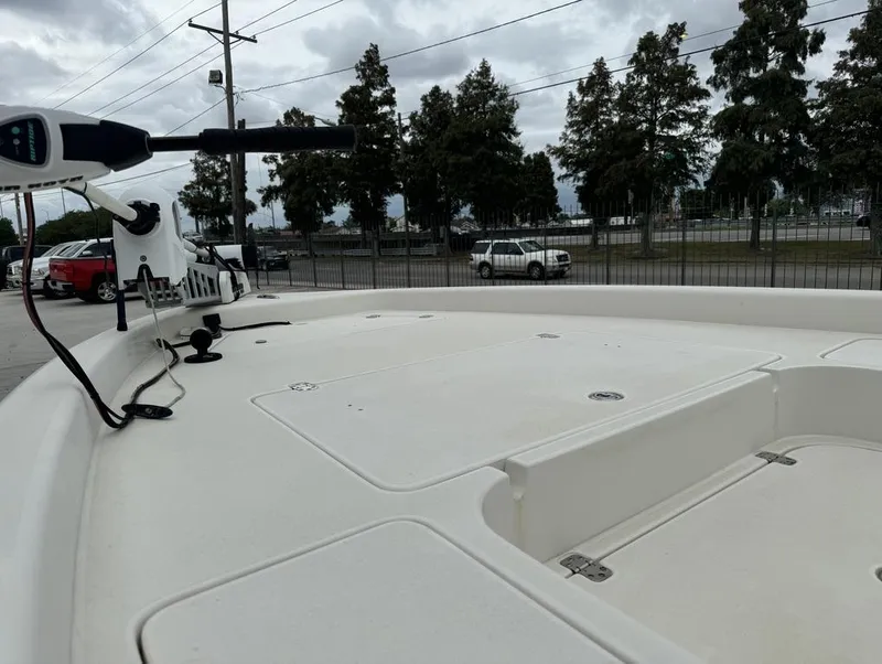Slide: The Image of 2013 ShearWater LTZ Series 25 boat deck with trolling motor, parked near trees. - 5
