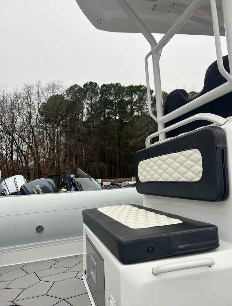 Slide: The Image of 2025 Highfield Sport 760 boat with cushioned seating, docked near trees. - 11