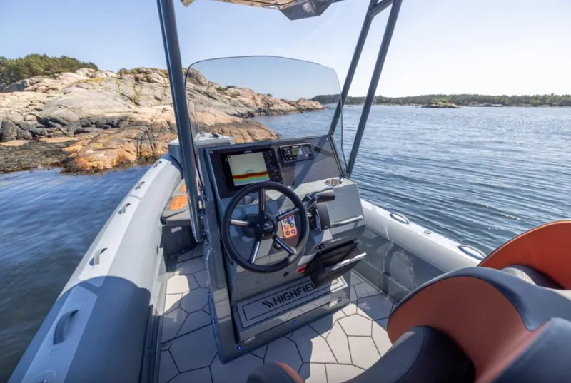 Slide: The Image of 2025 Highfield Sport 760 boat interior with steering wheel and navigation system. - 2