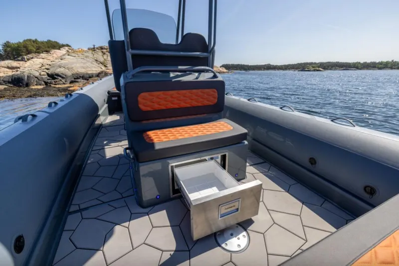 Slide: The Image of Highfield Sport 760 boat interior, 2025 model, featuring seating and storage on a scenic waterway. - 4