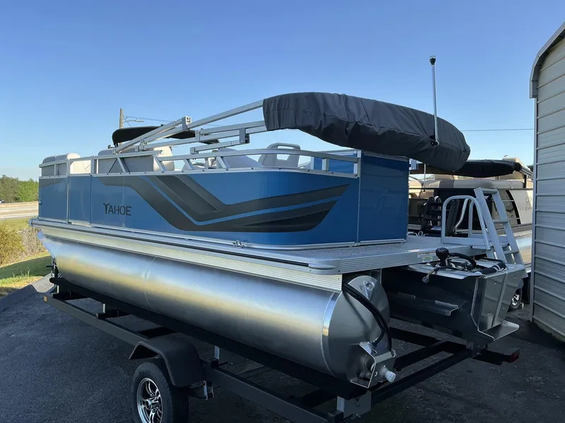 Slide: The Image of 2025 Tahoe Pontoon Boats Sport 17 REAR FISH on trailer, blue exterior, parked outdoors. - 3