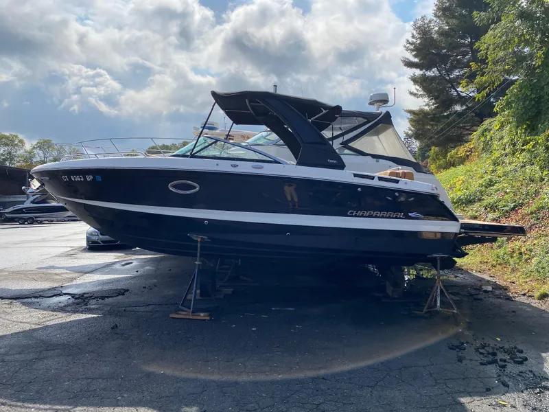 Slide: The Image of 2024 Chaparral 267 SSX boat on dry dock under cloudy sky. - 0