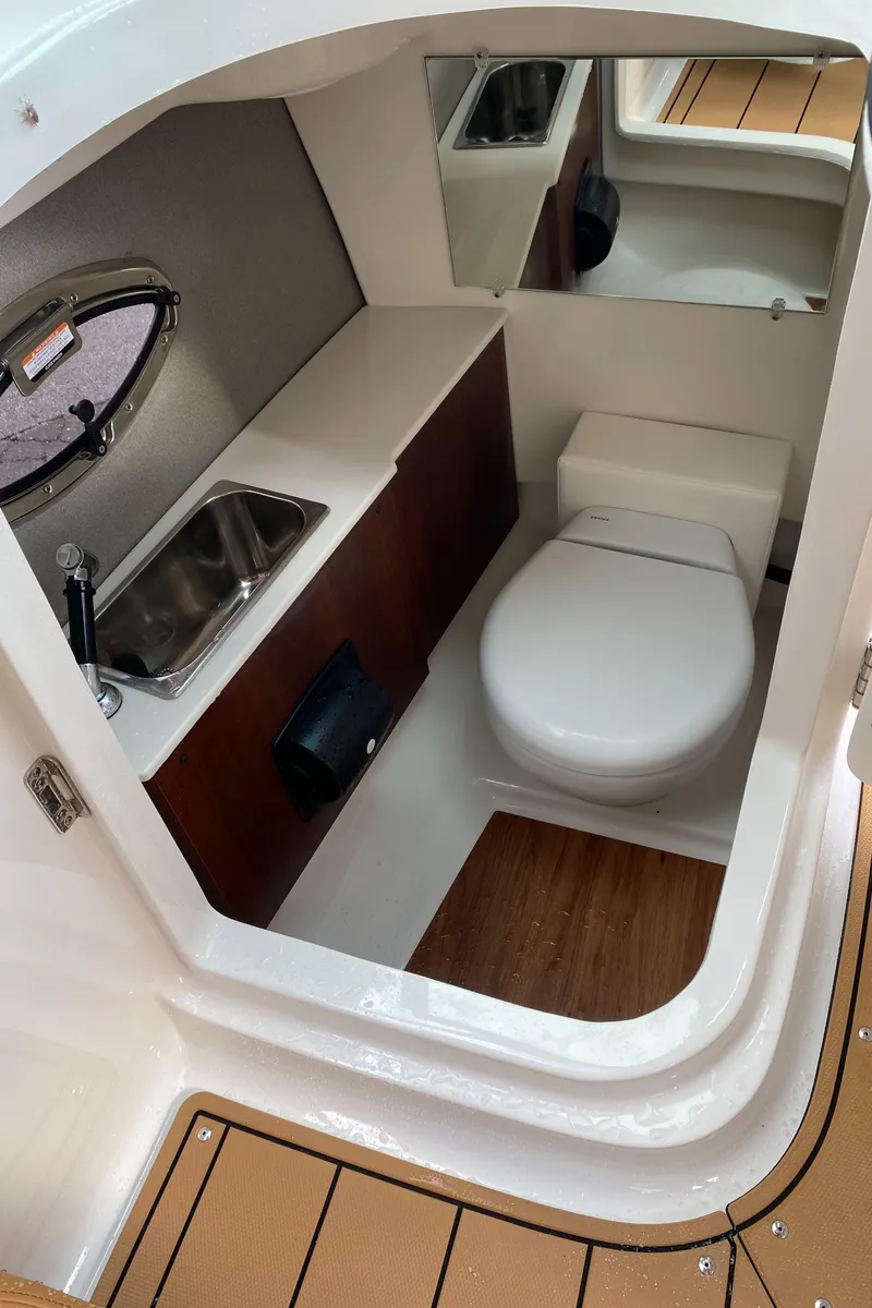 Slide: The Image of 2024 Chaparral 267 SSX boat interior with compact bathroom and sink. - 10