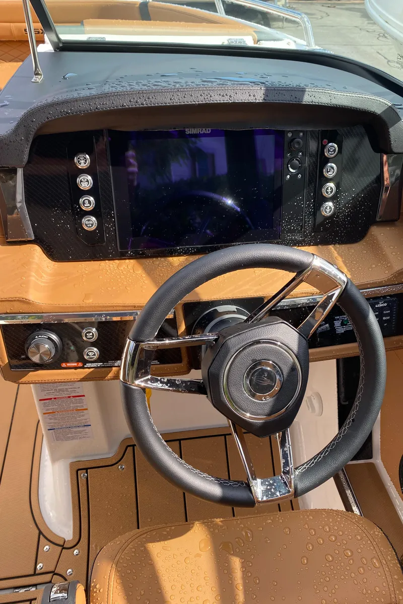 Slide: The Image of 2024 Chaparral 267 SSX boat dashboard with modern steering wheel and digital display. - 13
