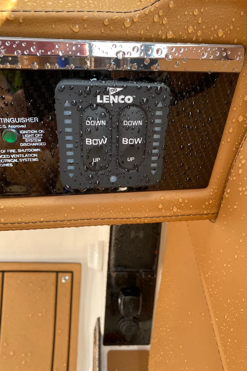 Slide: The Image of Lenco control panel on 2024 Chaparral 267 SSX boat, covered in water droplets. - 15