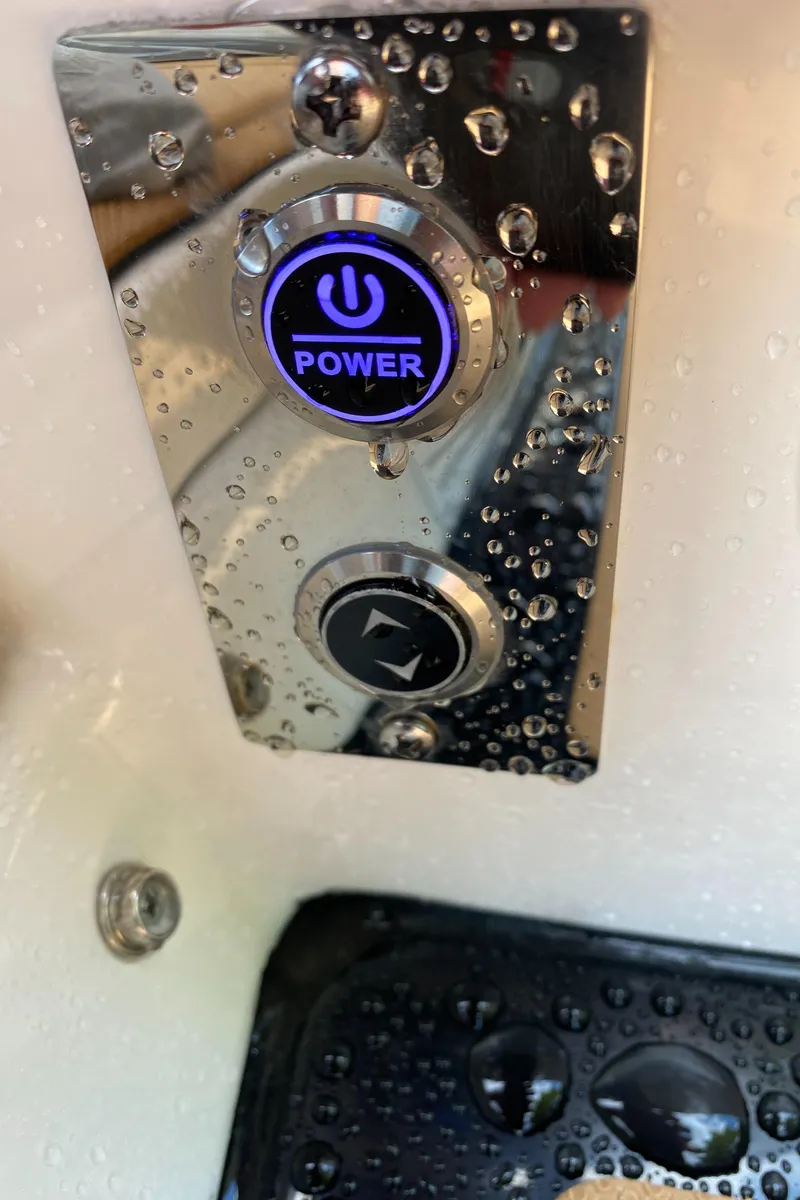 Slide: The Image of Close-up of 2024 Chaparral 267 SSX power button with water droplets. - 17