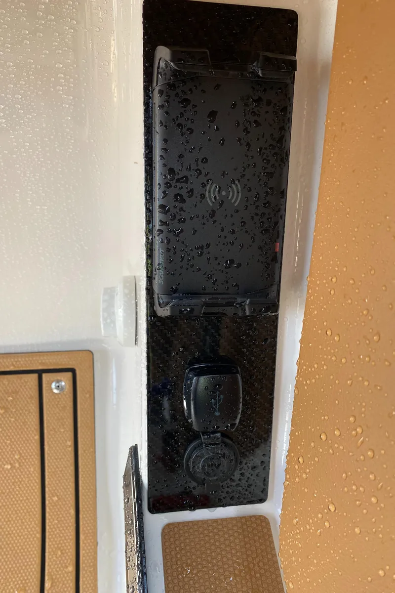 Slide: The Image of 2024 Chaparral 267 SSX boat dashboard with water droplets and charging port. - 18