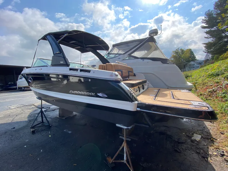 Slide: The Image of 2024 Chaparral 267 SSX boat on display under a sunny sky. - 2