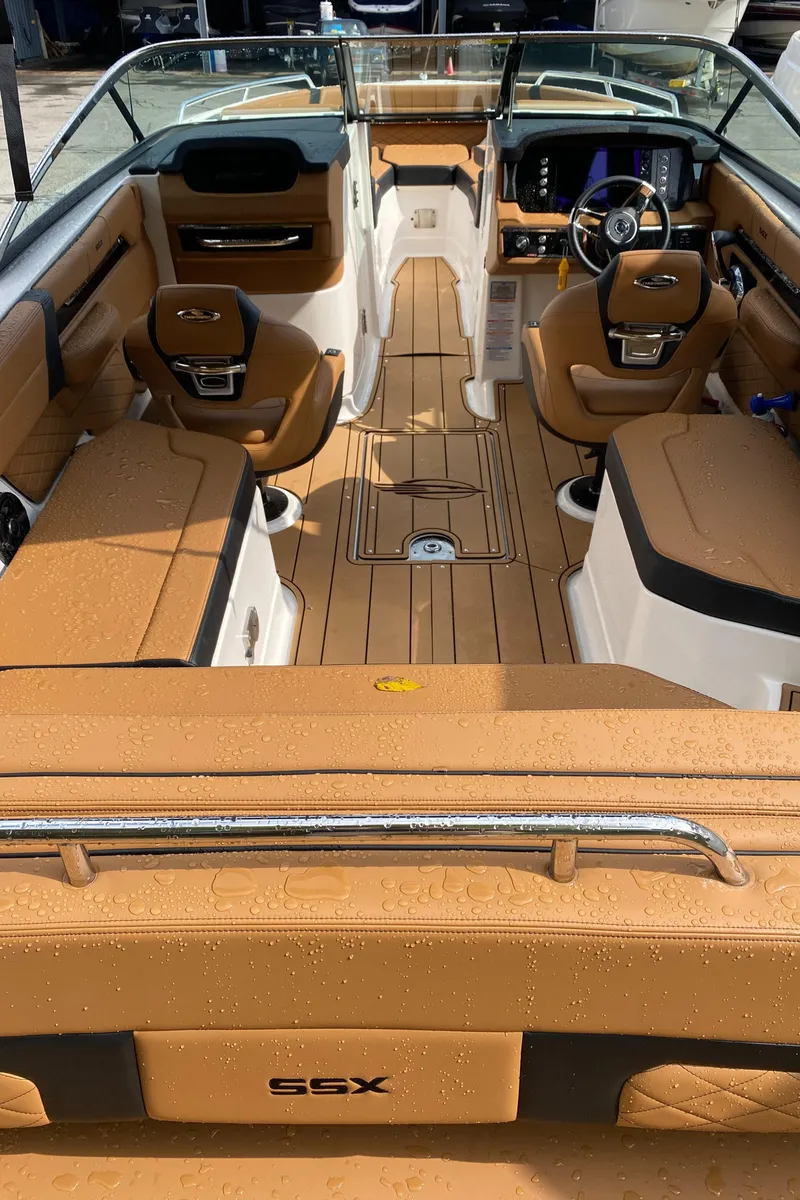 Slide: The Image of 2024 Chaparral 267 SSX boat interior with tan seating and modern dashboard. - 5