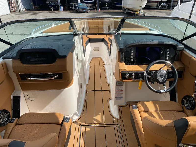 Slide: The Image of 2024 Chaparral 267 SSX boat interior with modern dashboard and tan seating. - 7