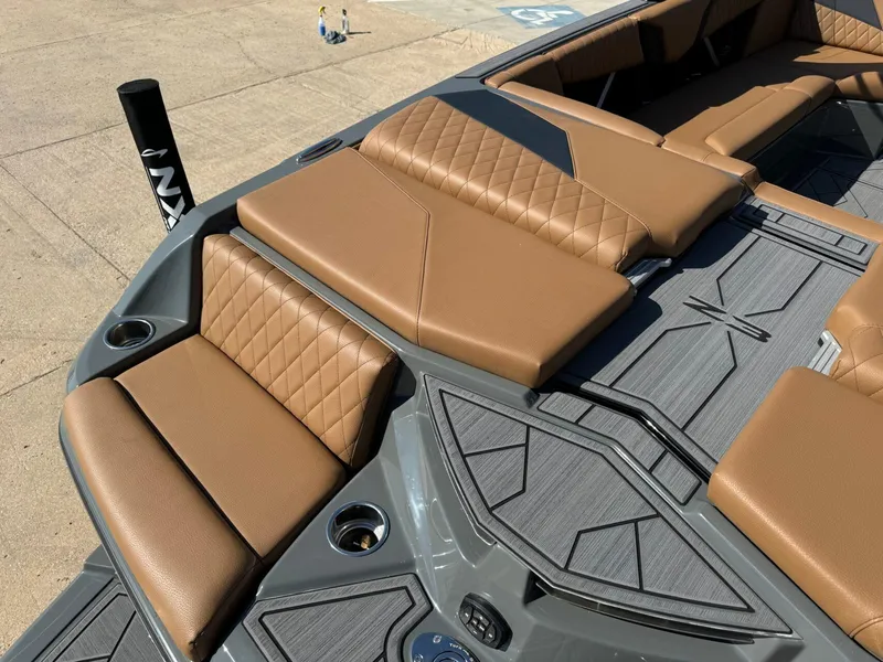 Slide: The Image of 2024 Tigé Z3 boat interior with brown quilted seats and gray flooring. - 10
