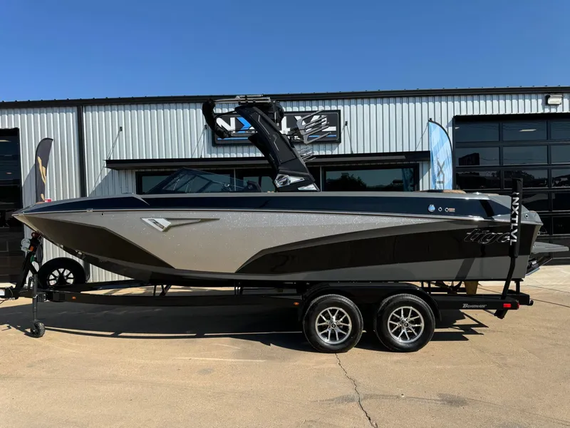 Slide: The Image of 2024 Tigé Z3 boat on trailer, sleek design, parked outside a modern building. - 2