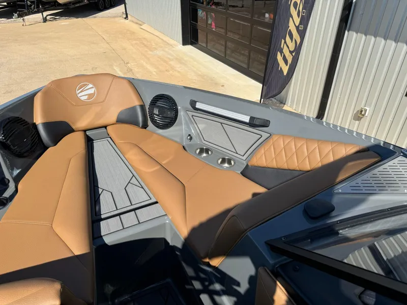 Slide: The Image of 2024 Tigé Z3 boat interior with tan and gray seating, cup holders, and speakers. - 30