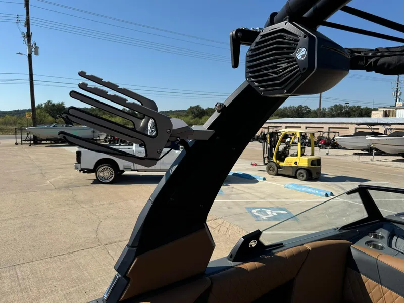 Slide: The Image of 2024 Tigé Z3 boat with wakeboard rack and speaker, parked in a marina lot. - 32