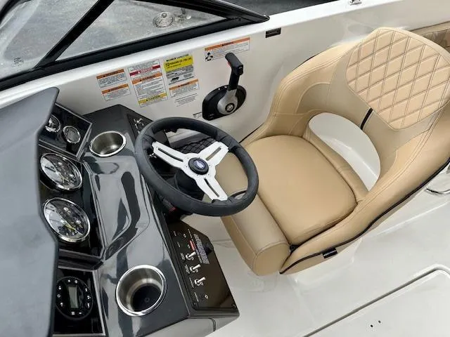 Slide: The Image of 2025 Bayliner VR6 Bowrider I/O cockpit with beige seating and modern dashboard controls. - 10