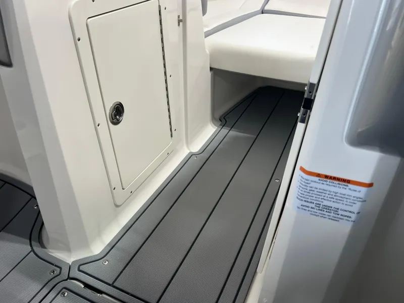 Slide: The Image of 2025 Chaparral 21 SSi boat interior with gray flooring and storage compartment. - 10