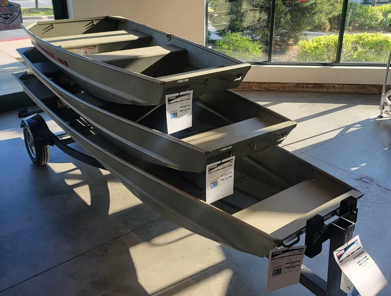 Slide: The Image of 2025 Tracker Grizzly 1236 Utility boats stacked on a trailer in a showroom. - 33