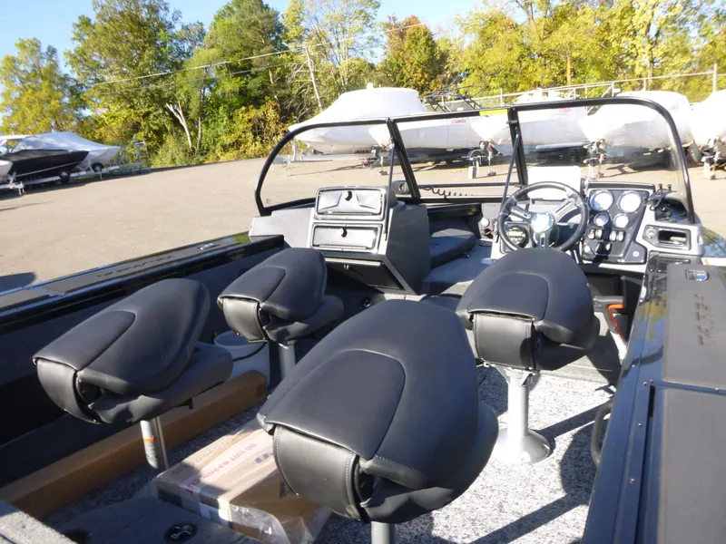 Slide: The Image of 2025 Tracker Targa V-18 Combo boat interior with four black seats and control panel. - 24