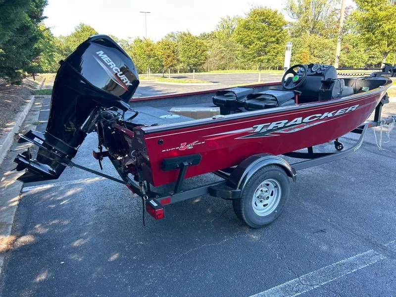Slide: The Image of 2025 Tracker Super Guide V-16 SC boat with Mercury outboard motor in a parking lot. - 3
